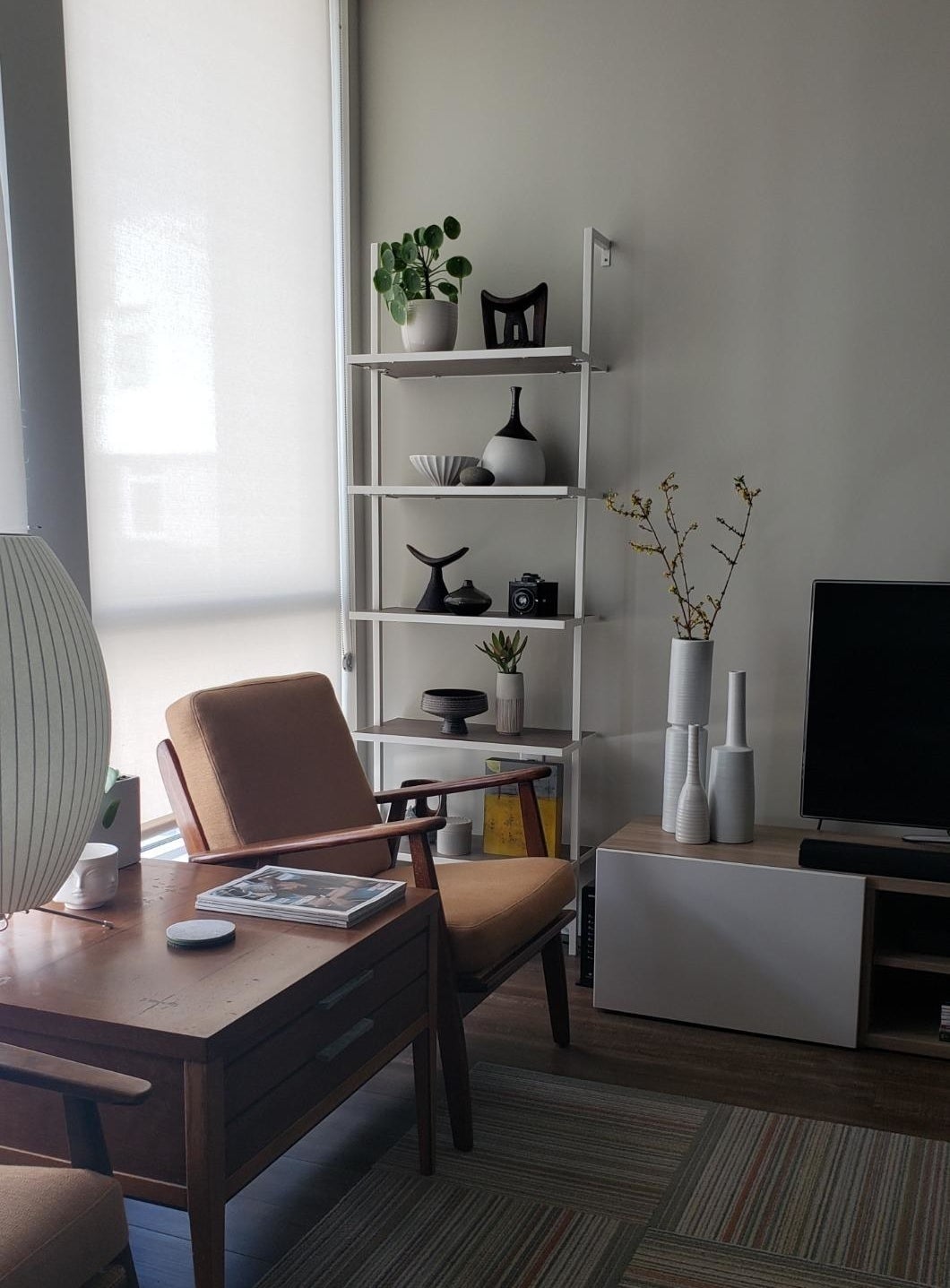 reviewer photo of a thin white metal frame bookshelf with five shelves