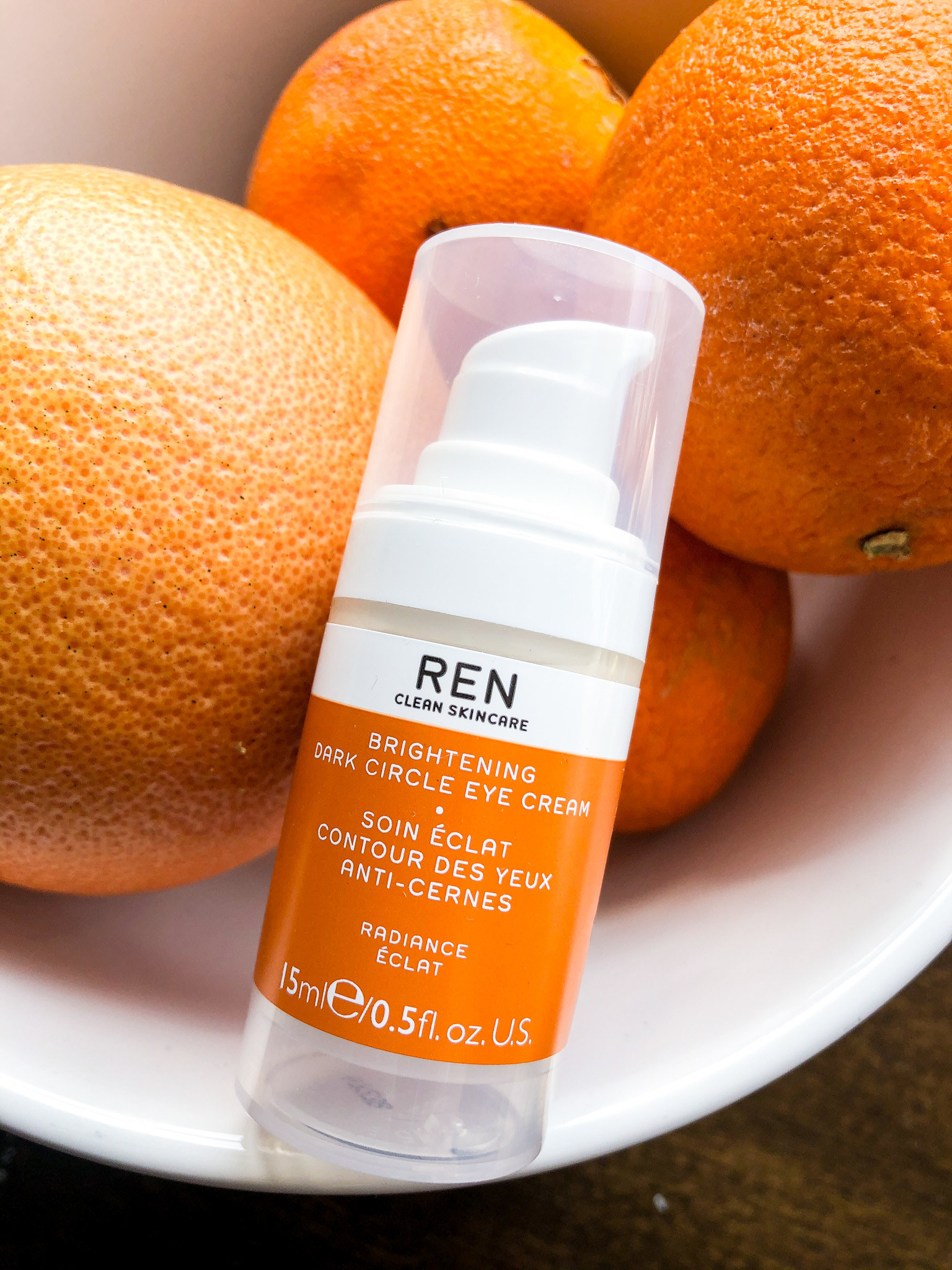 The eye cream nestled into a bowl of oranges