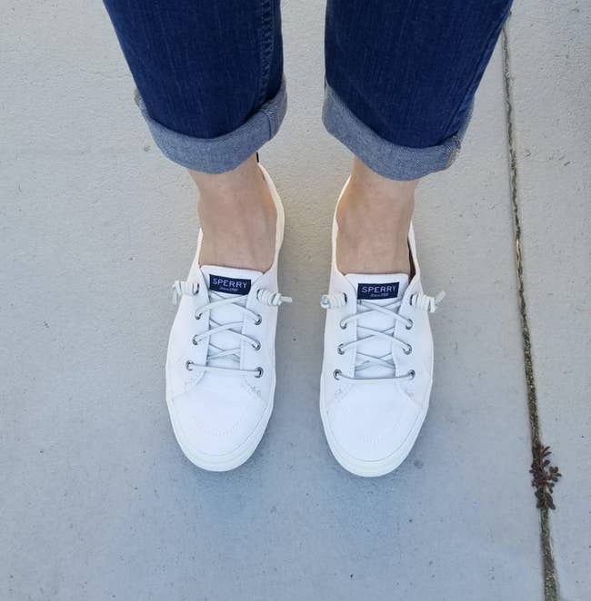the white sperry sneakers on a reviewer's feet 