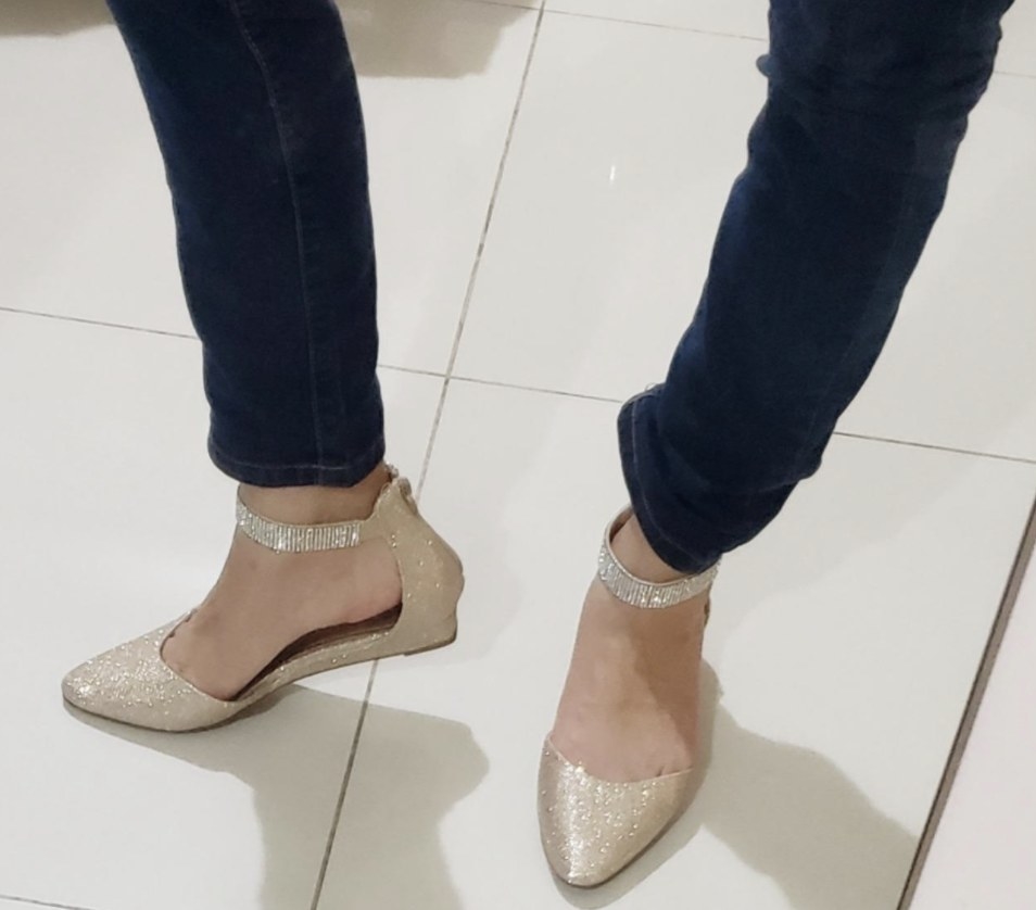 Reviewer photo of beige glittery pointed flats with an ankle strap