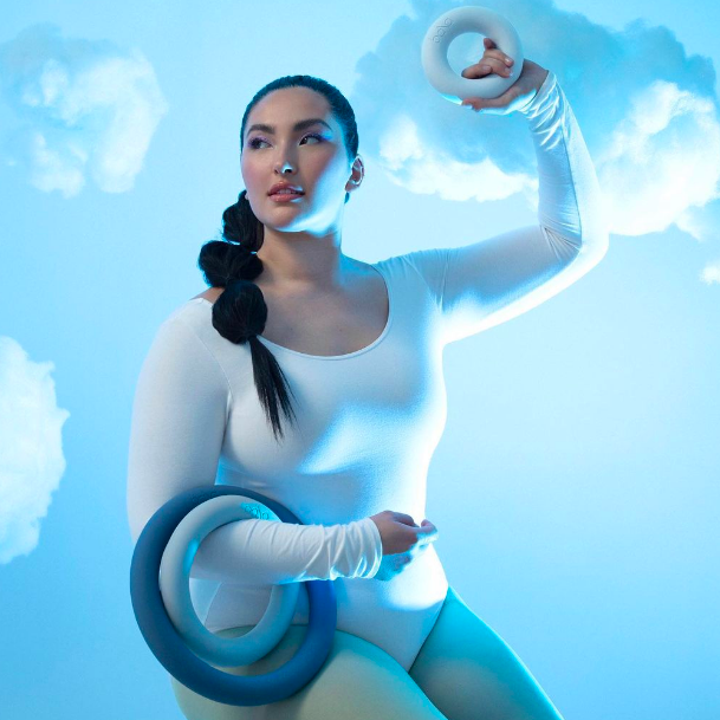 Model holding up three workout rings of different sizes