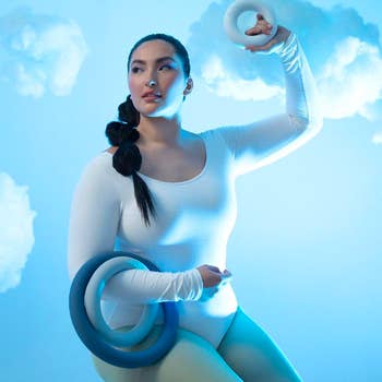 Model holding up three workout rings of different sizes 