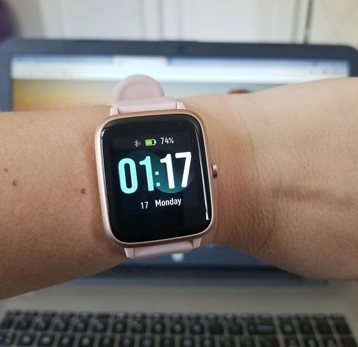 Reviewer wearing smart watch with clock interface on screen
