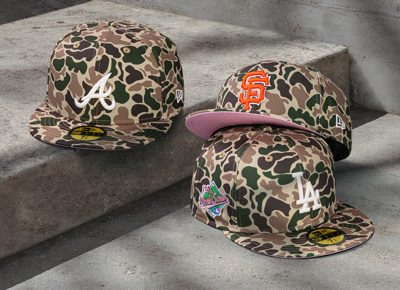Three fitted camo baseball caps with colorful team logos and patches