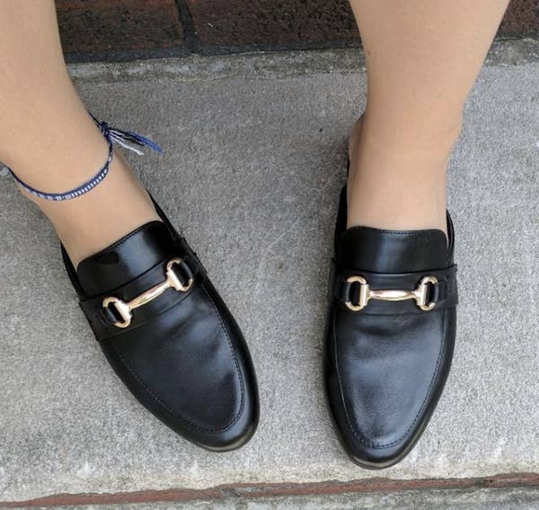 Reviewer pic of the black slip on loafers with a gold buckle on top