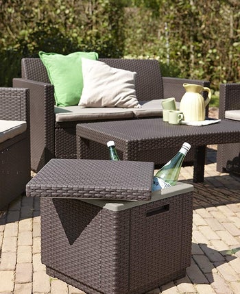 a woven ottoman with the lid askew and two bottles poking out 