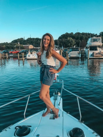 reviewer wearing blue paperbag shorts while on a boat