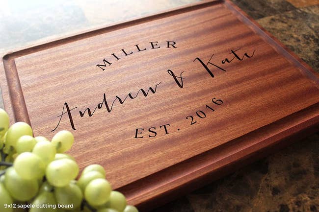 a wood cutting board that says andrew and kate est 206