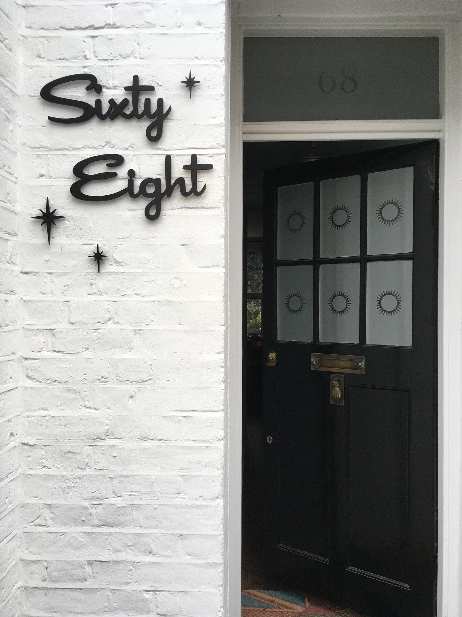 sixty eight written in a curvy black font next to someone&#x27;s front door