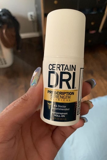 reviewer holding up a packacge of certain dri prescription strength deodorant