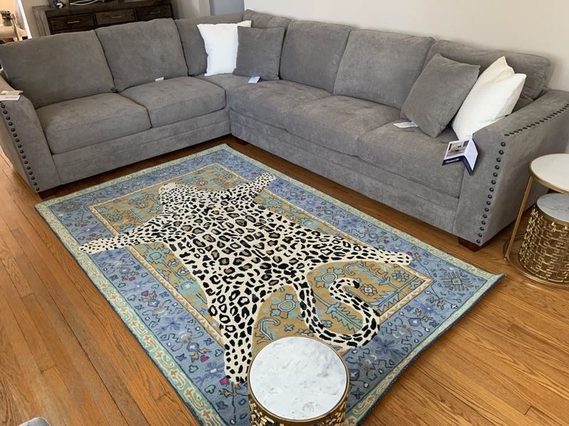 A rug with an illustration of a cheetah is playfully drawn on top of a more traditional rug, giving the illusion that there are two rugs layered on top of each other
