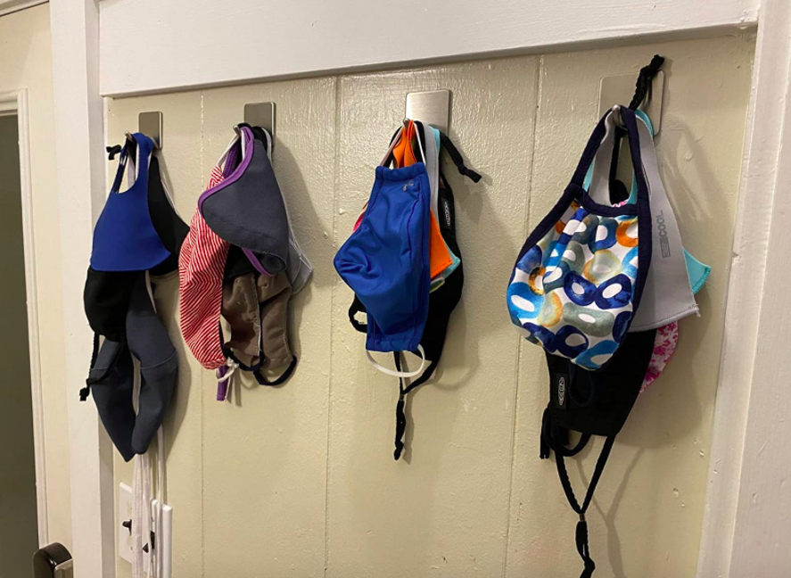 A customer review photo of the hooks on a wall holding all their masks