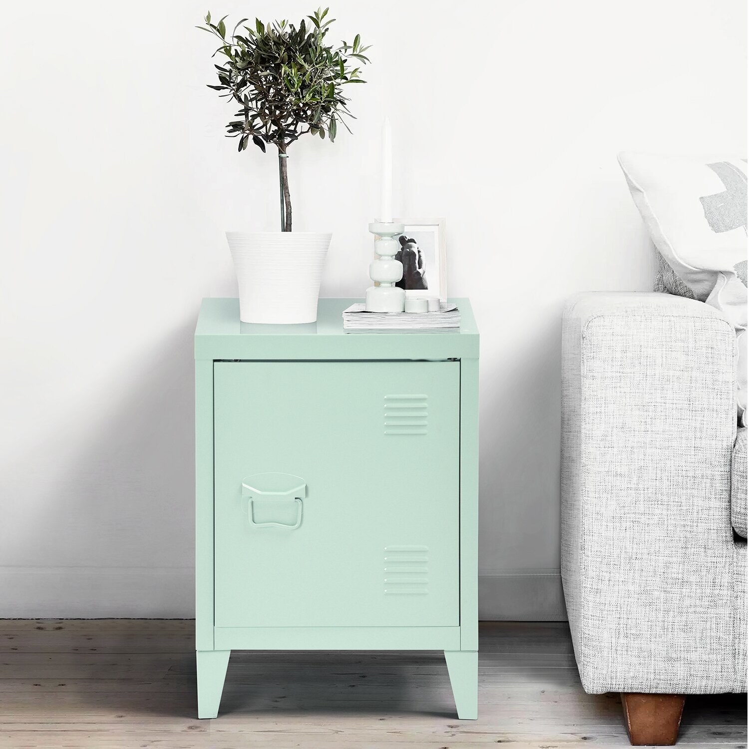 The end table, which has a hinged, forward-swinging door like a locker, in mint green