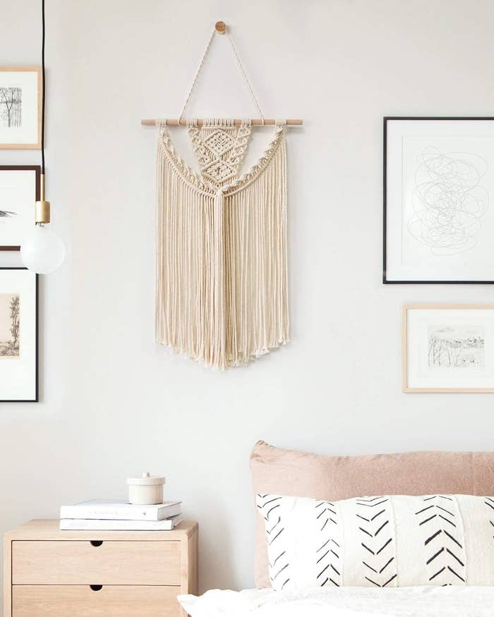 a hanging macrame wall piece in a bedroom 