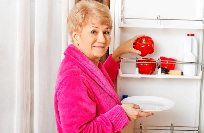 An old woman getting stuff from her fridge