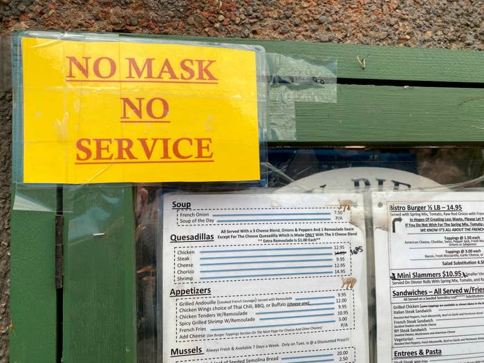 A sign posted outside a restaurant in Queens, New York, reads &quot;no mask, no service&quot;