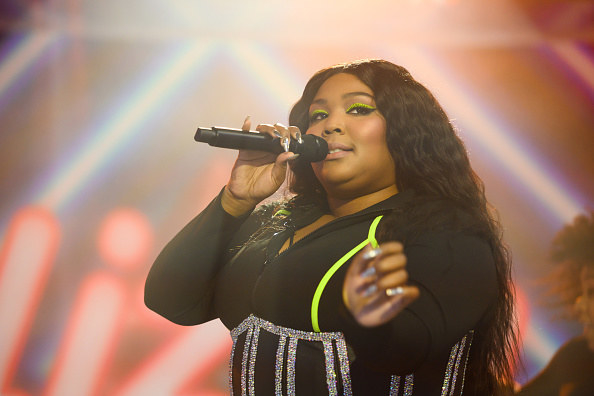 Lizzo singing into a microphone