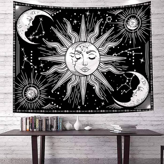 a rectangular wall tapestry with suns and moons designed on it 