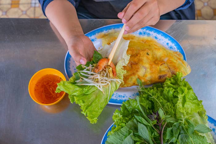 一个女人把越南绉生菜包。