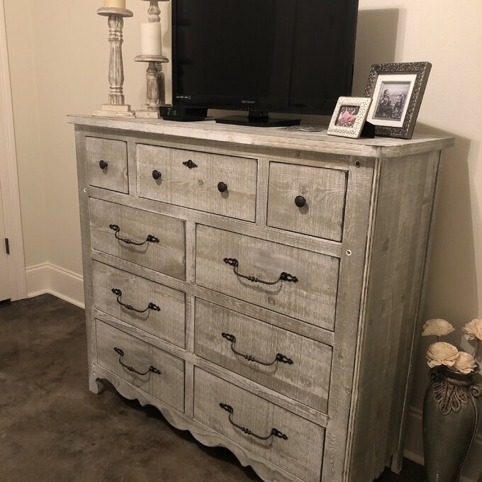 A reviewer photo of the dresser, which has arched black metal handles, in gray