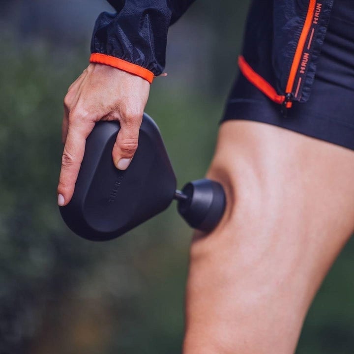 Model using the massager on their thigh
