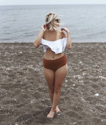 A person wearing a white and maroon bathing suit