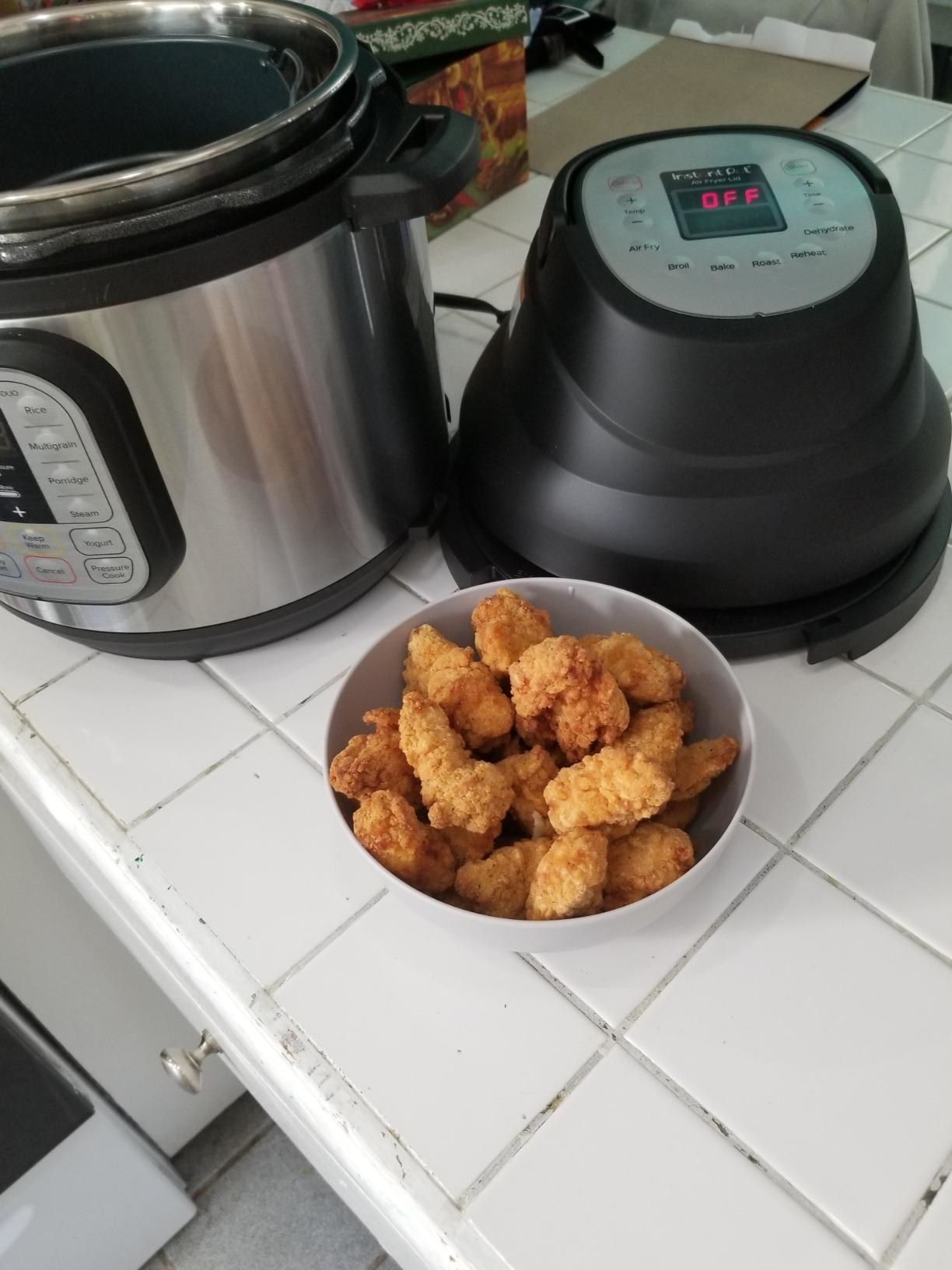 The lid, Instant Pot, and some popcorn chicken a reviewer made with them. It looks so good I wanna eat my computer screen.