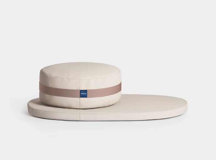 A modern minimalist round cushion on a matching oval mat 