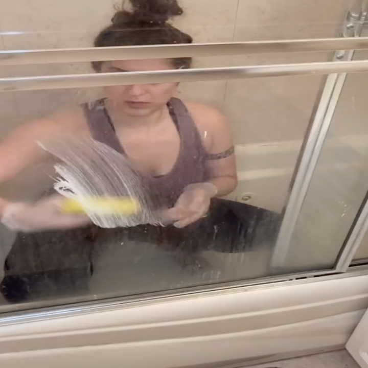 person cleaning shower with stove top cleaner