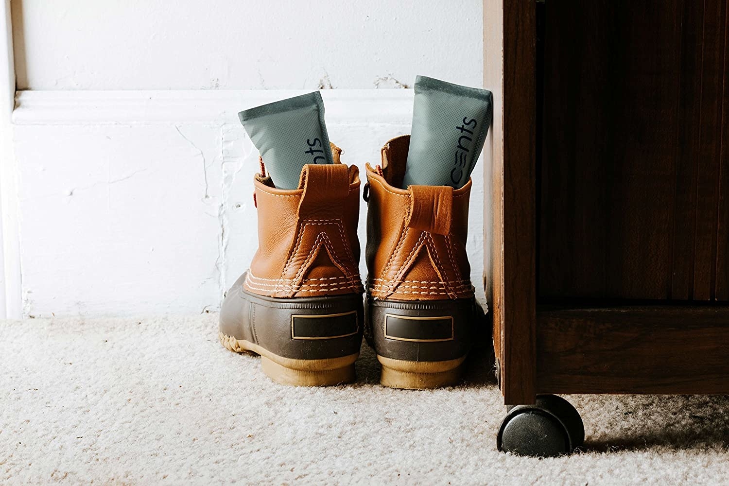 A set of a grey shoe deodorizers in a pair of brown work boots.