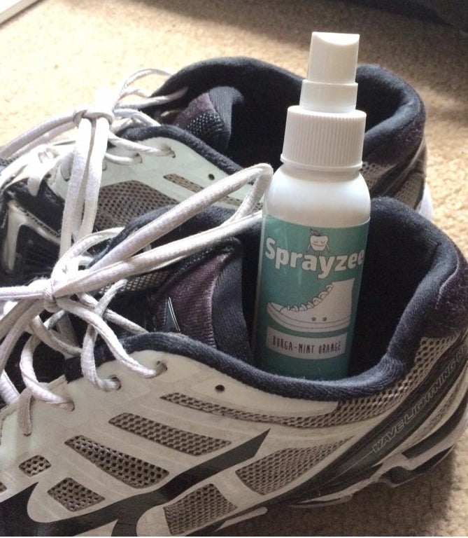 A green bottle of spray in a black and white shoe