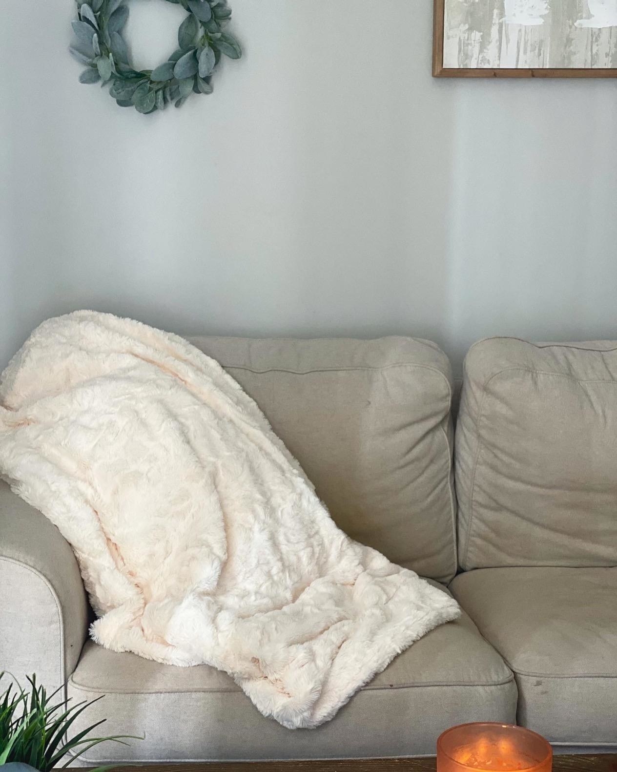 reviewer photo of the plush blanket thrown over a couch