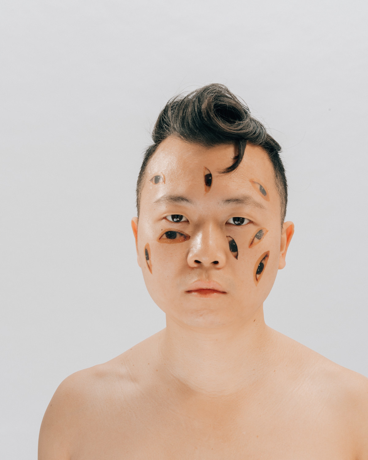 A self-portrait of the photographer with temporary eye tattoos on his face