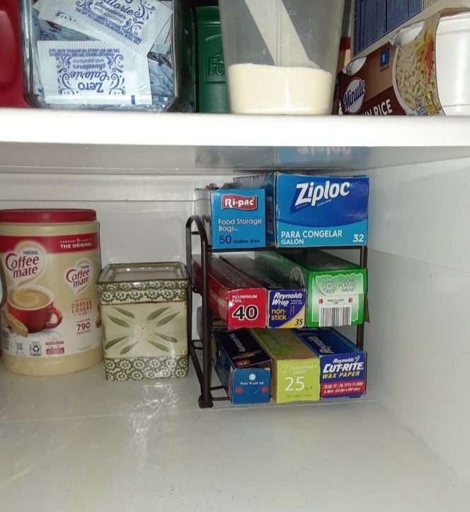 A bronze plastic wrap storage unit holding wrap in a cabinet