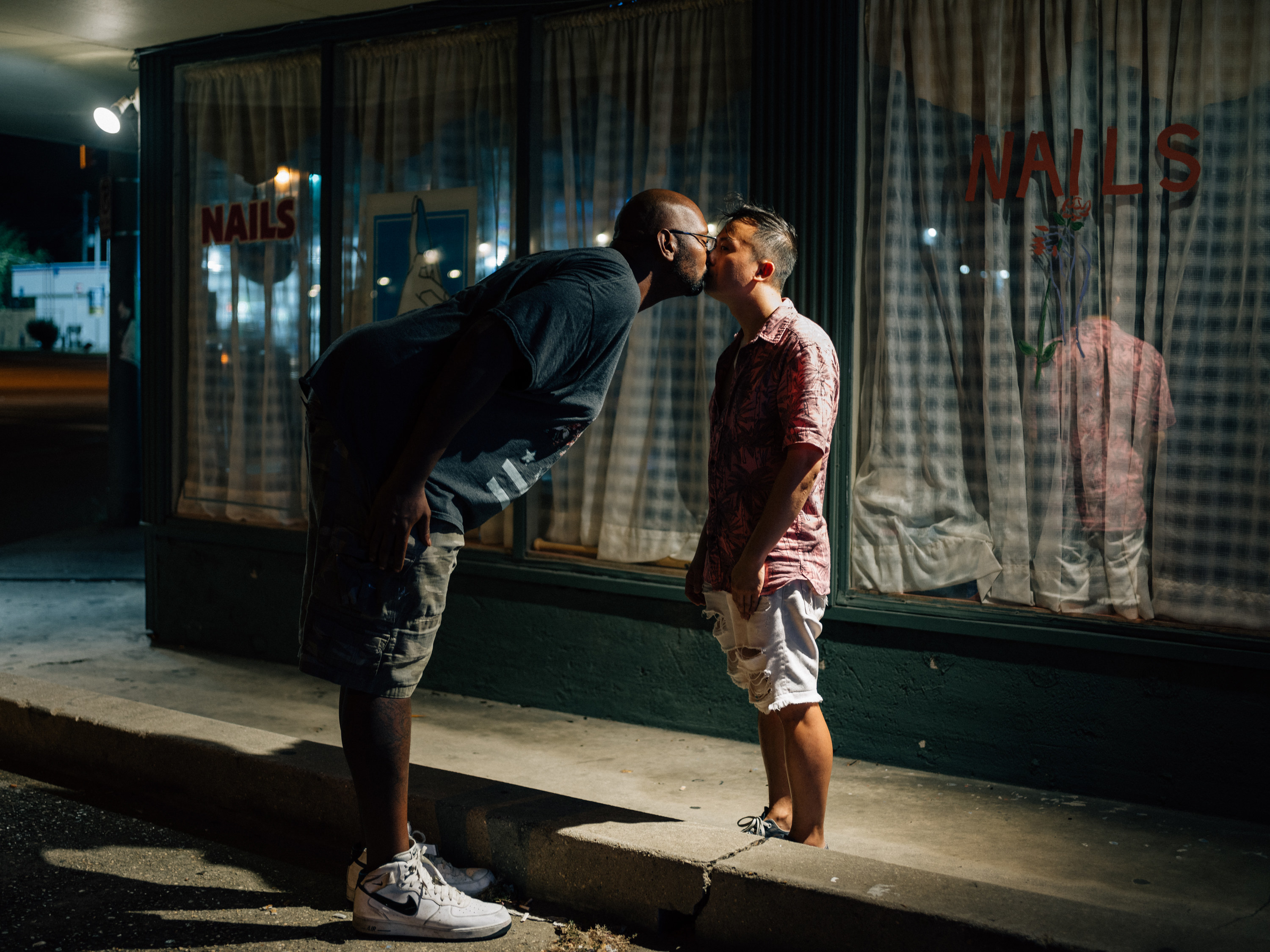 A man leaning over and kissing the photographer