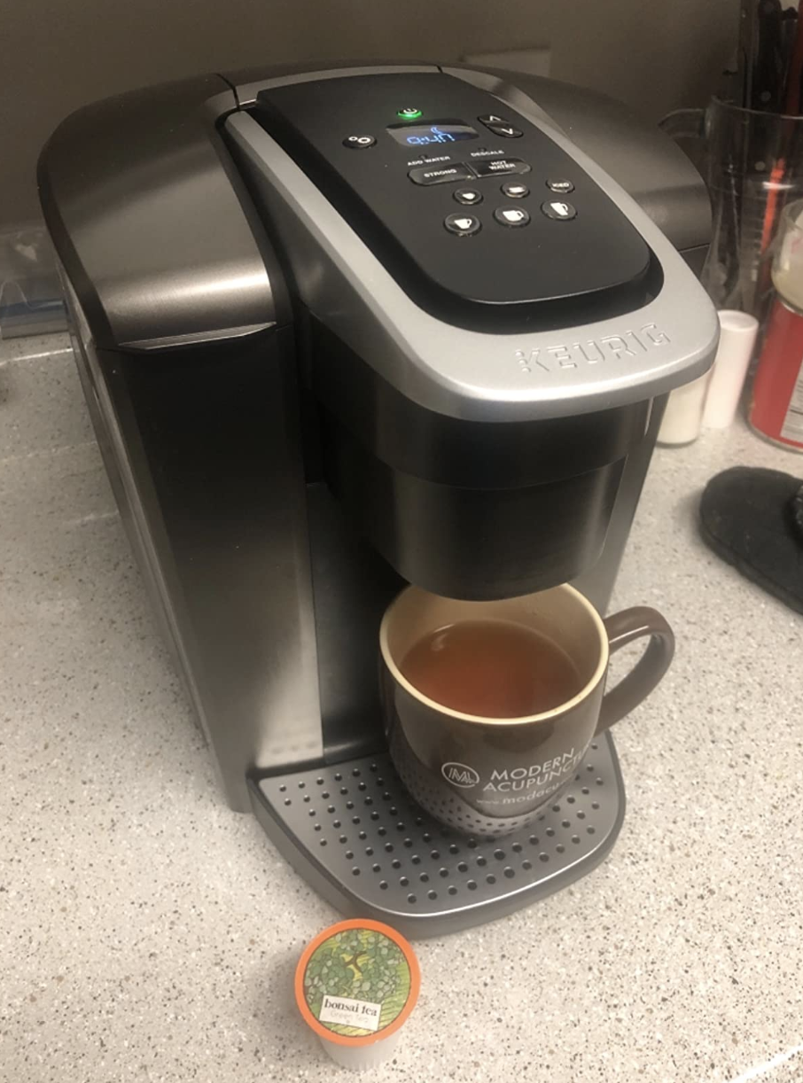 The black Keurig dispensing coffee into a mug 