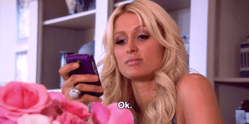 Paris Hilton looking at her phone and saying, &quot;Ok&quot;