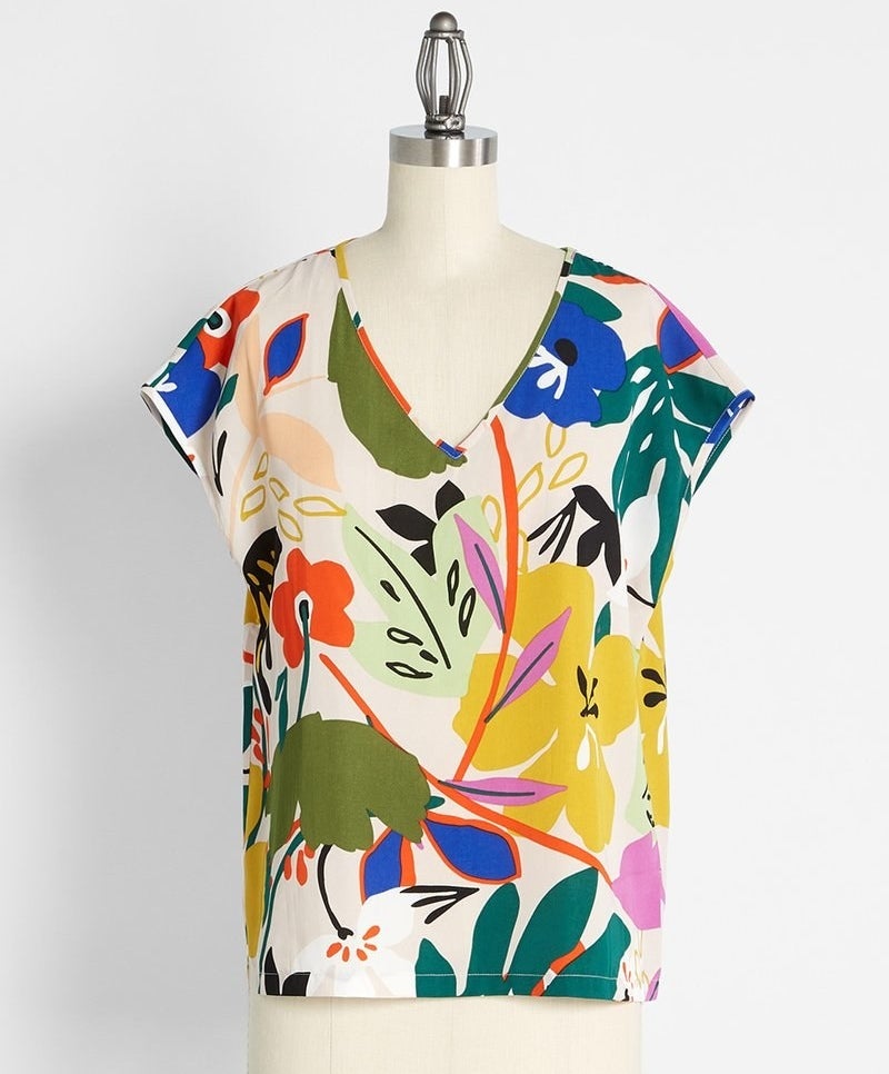 a mannequin wearing a short sleeve T-shirt with a V-neckline with a retro tropical floral print 