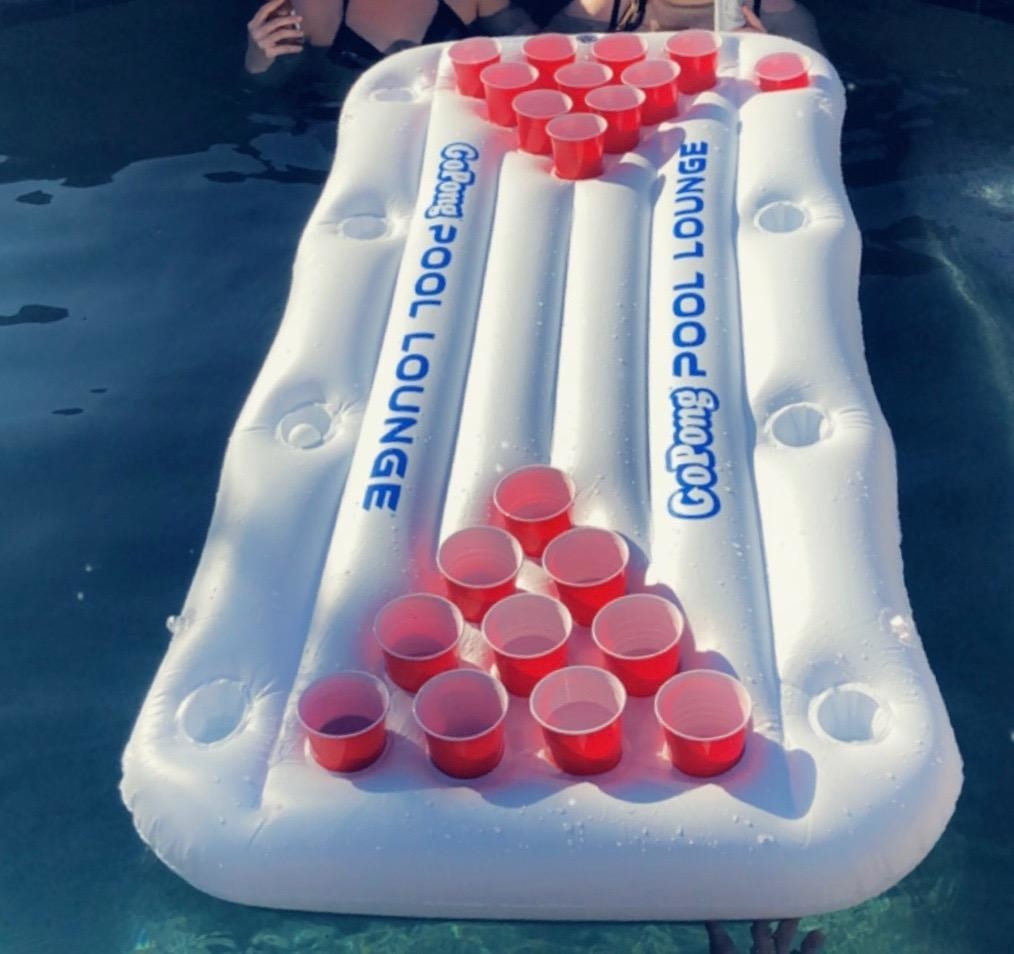White pool float with slots for cups to play beer pong