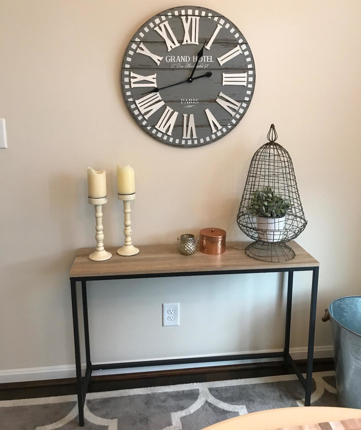 reviewer photo of a skinny console table with wood top and metal legs against a wall