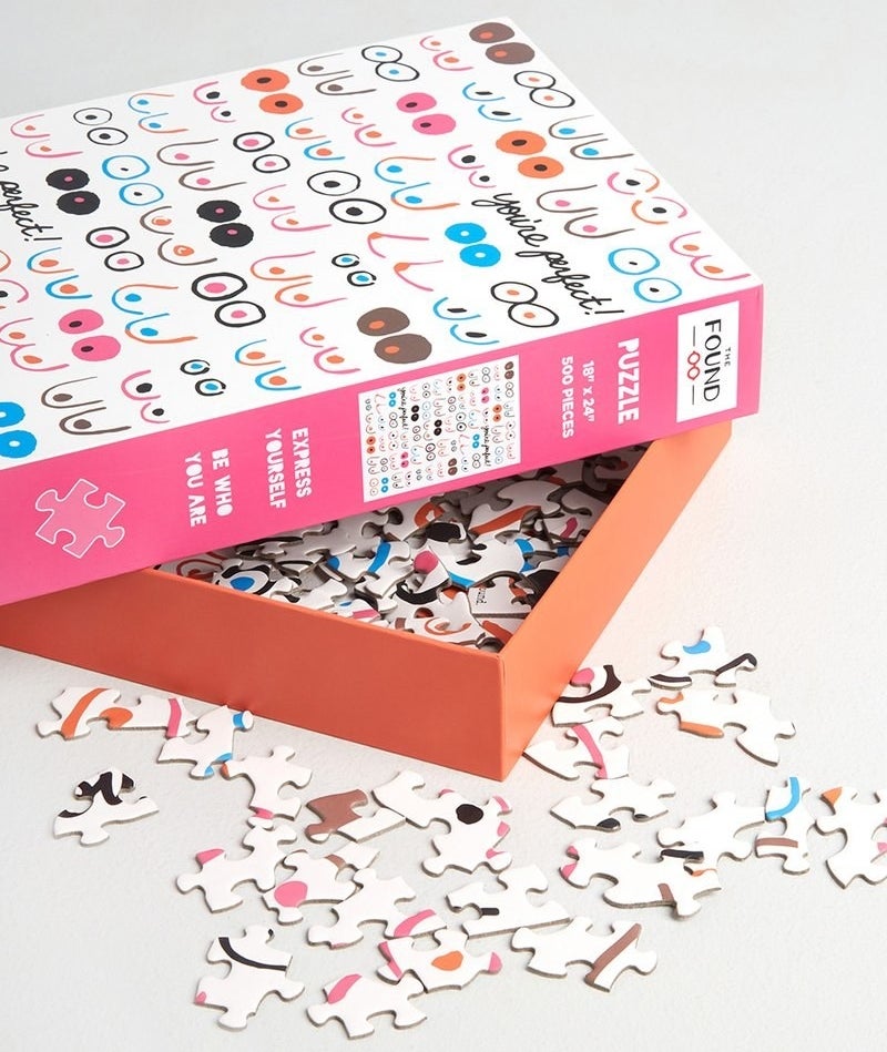 an open box with a picture of illustrated boobs and puzzle pieces spilling out 