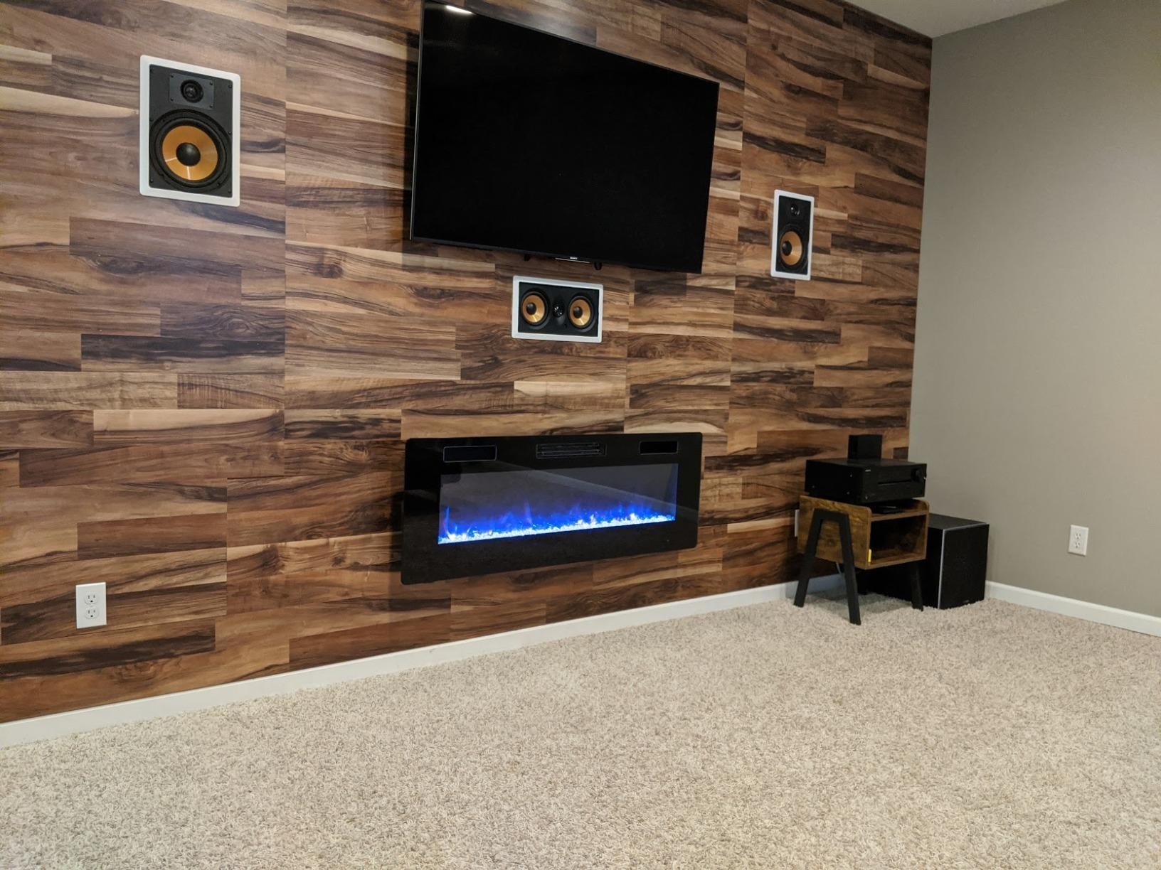 reviewer's electric fireplace mounted underneath a television 