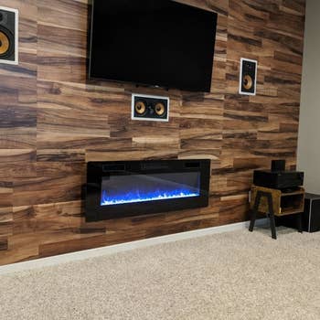 reviewer's electric fireplace mounted underneath a television 