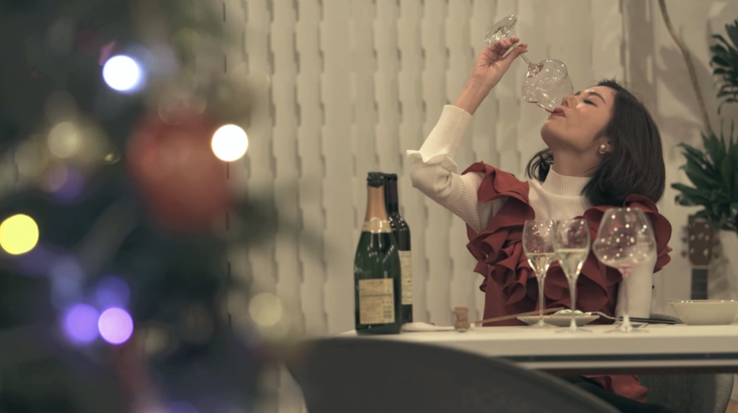 Seina drinking a glass of wine alone.