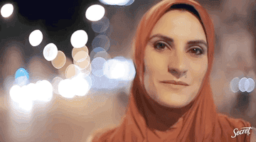 GIF of a woman wearing a hijab and another woman speaking at a podium.