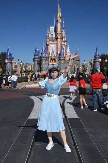 another reviewer in the skirt in light blue in front of cinderella's castle