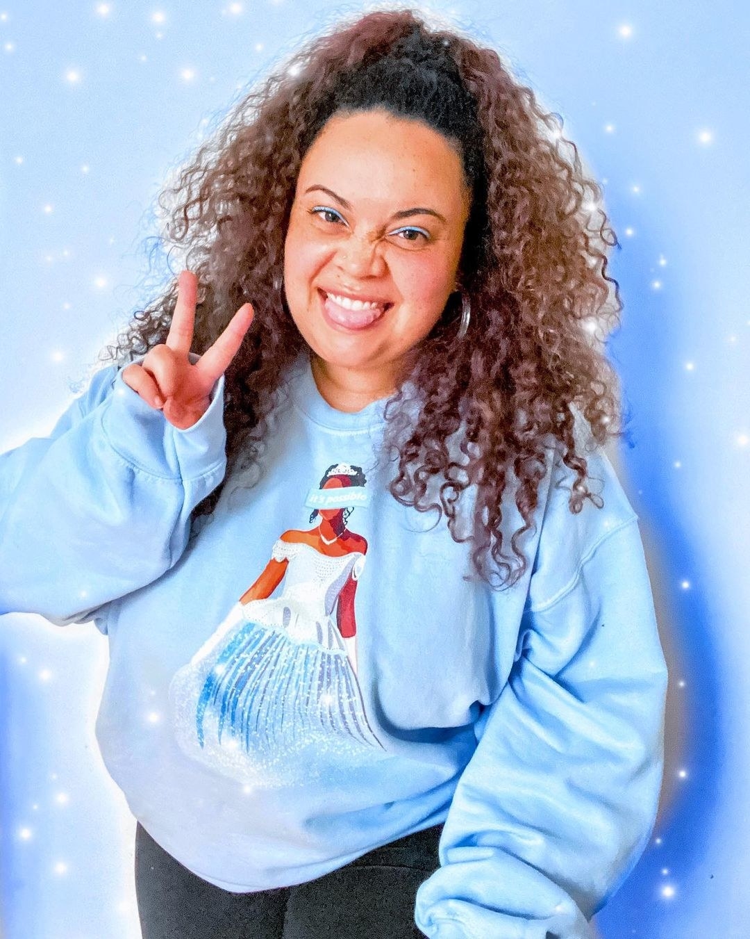 A BuzzFeed editor in a light-blue sweatshirt with an illustration of  Brandy as Cinderella on it