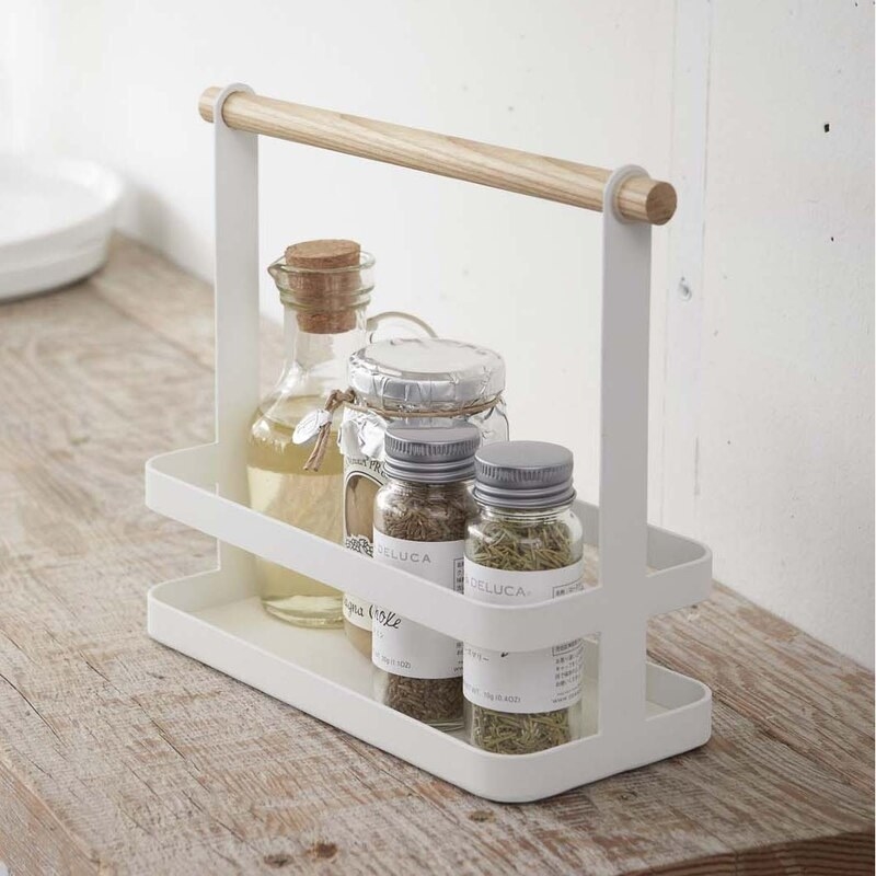 A minimalist spice rack filled with several bottles of dried herbs