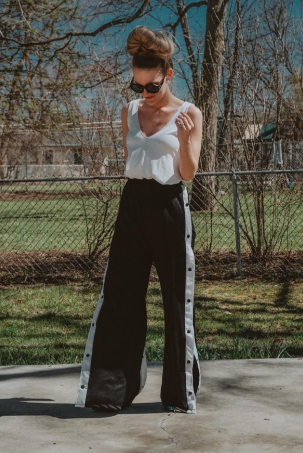 Reviewer wearing the pants in black and white with a white top and sunglasses