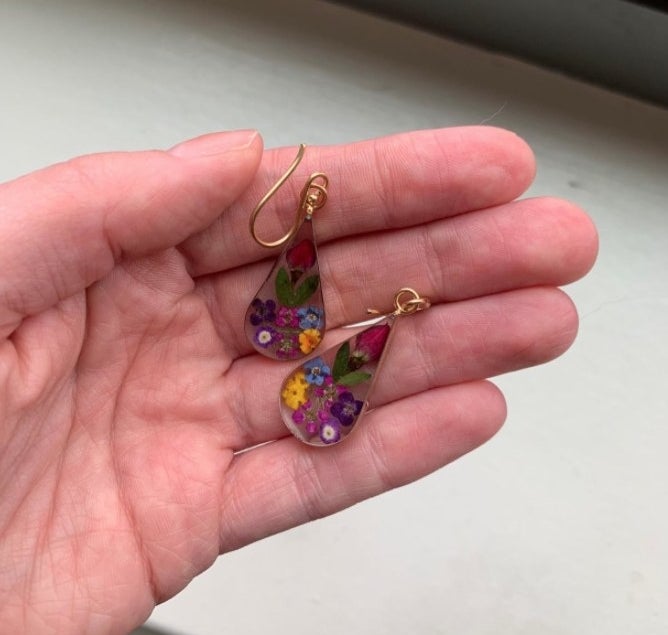 A reviewer holding the earrings 